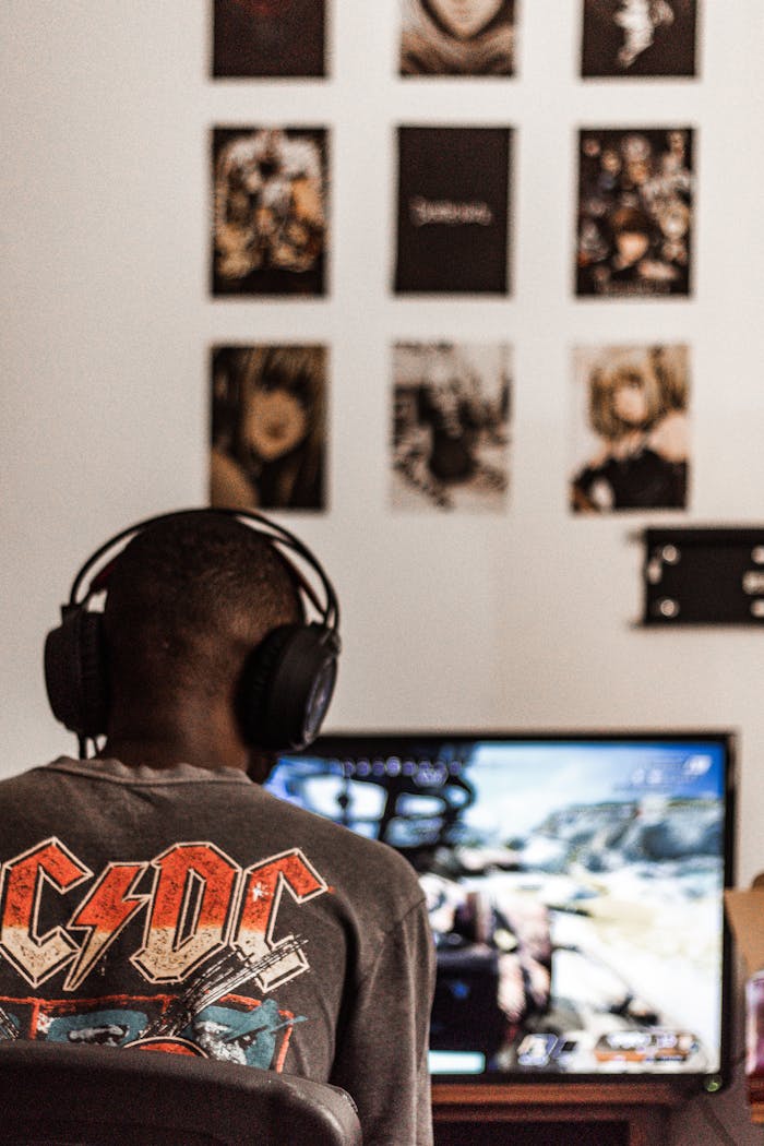 gallery-4 Person wearing headphones playing video game on computer screen at home.